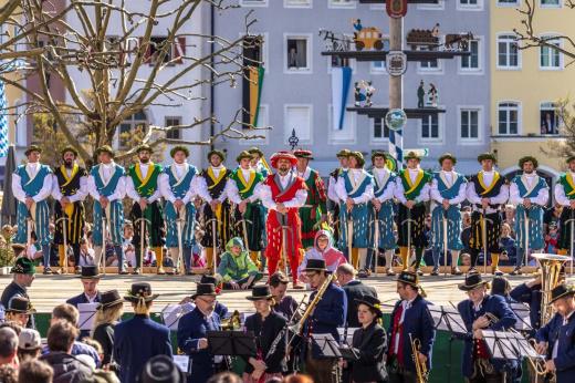 Eine Gruppe von Künstlern in traditionellen Kostümen führt auf der Bühne einen kulturellen Tanz auf.