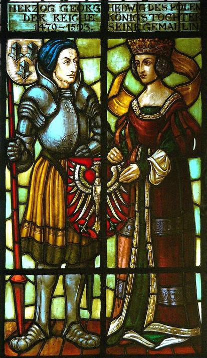 Stained glass window featuring a man and woman in ornate armor, showing intricate designs and vibrant colors.