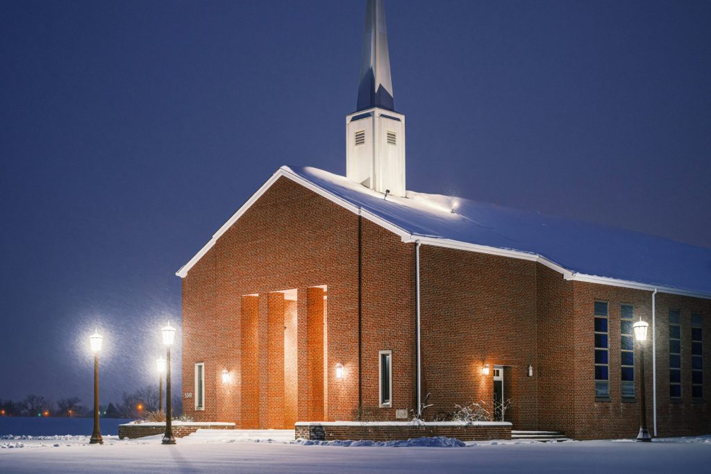 eine Kirche mit einem nachts beleuchteten Kirchturm